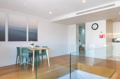 a dining room with a glass table and chairs at LovelyStay - Primrose 2BR Flat with Free Parking, AC and Balcony in Porto