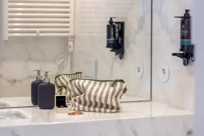 a bathroom with a counter with two bottles on it at LovelyStay - Primrose 2BR Flat with Free Parking, AC and Balcony in Porto