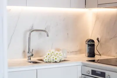 a kitchen counter with a sink and a faucet at LovelyStay - Primrose 2BR Flat with Free Parking, AC and Balcony in Porto