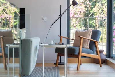 a living room with a table and chairs and a lamp at LovelyStay - Primrose 2BR Flat with Free Parking, AC and Balcony in Porto