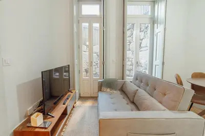 a living room with a couch and a television at Cozy Flat with Terrace by Hosty in Porto