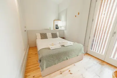 a white bedroom with a bed with two towels on it at Cozy Flat with Terrace by Hosty in Porto