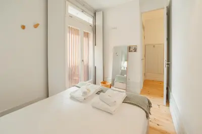 a white bedroom with a large bed with white pillows at Cozy Flat with Terrace by Hosty in Porto
