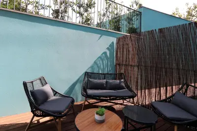 a patio with three chairs and a table and a fence at HM - Segredo do Porto in Porto