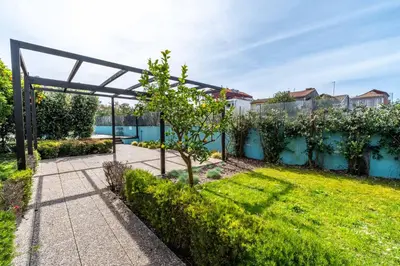 a garden with a pergola and a small tree at HM - Segredo do Porto in Porto