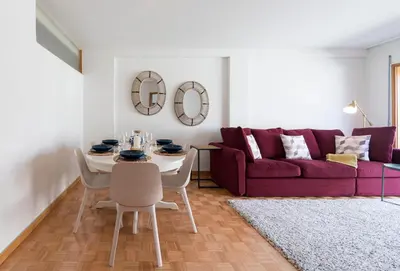 a living room with a red couch and a table and chairs at Rua de Camões in Porto