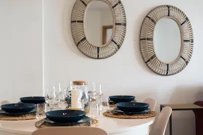 a table with plates and glasses and mirrors on the wall at Rua de Camões in Porto
