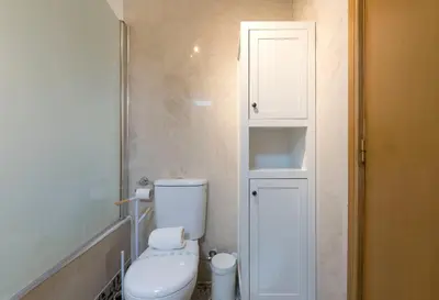 a small bathroom with a toilet and a cabinet at Rua de Camões in Porto