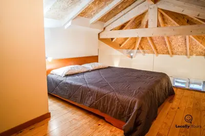 a bedroom with a bed in a room with wooden floors at Locally Yours Oporto Apartments in Porto