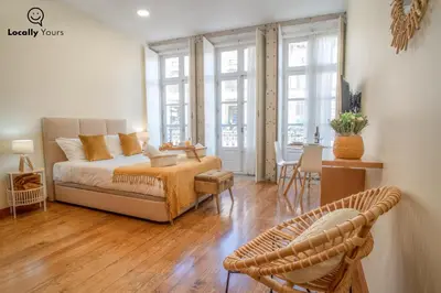 a living room with a bed and a table and chairs at Locally Yours Oporto Apartments in Porto