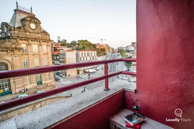 a red balcony with a view of a city at Locally Yours Oporto Apartments in Porto