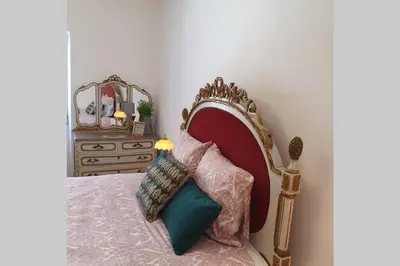 a bedroom with a bed with a red headboard and pillows at Charming Clérigos Studio in Porto