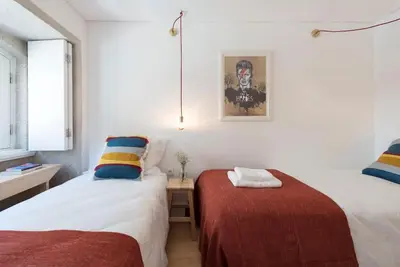 a bedroom with two beds and a table and a window at PinPorto Downtown in Porto