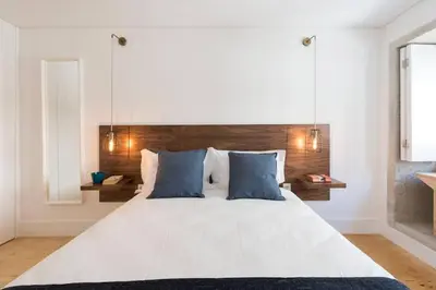 a bedroom with a large white bed with blue pillows at PinPorto Downtown in Porto