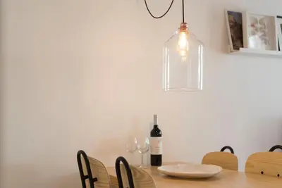 a dining room table with a bottle of wine and a lamp at PinPorto Downtown in Porto