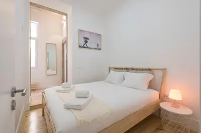 a bedroom with a large white bed with a lamp at Rua do Freixo in Porto