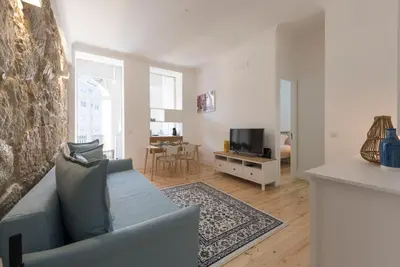 a living room with a blue couch and a television at Rua do Freixo in Porto