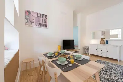 a living room with a table and a dining room at Rua do Freixo in Porto