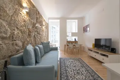 a living room with a blue couch and a tv at Rua do Freixo in Porto