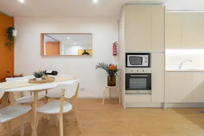 a kitchen and dining room with a table and a microwave at Host Wise - Colorful Bright Flat with Balcony in Porto
