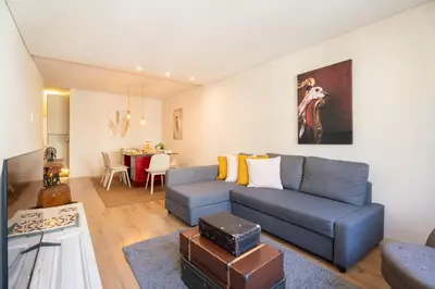 a living room with a blue couch and a table at Host Wise - Colorful Bright Flat with Balcony in Porto