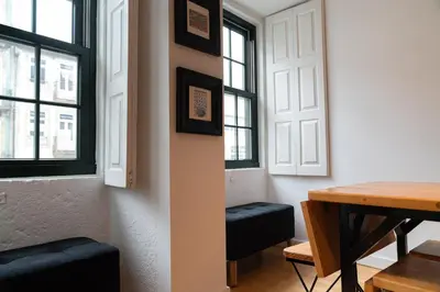 a dining room with a table and some windows at Clerigos Townhouse Porto by PCH in Porto