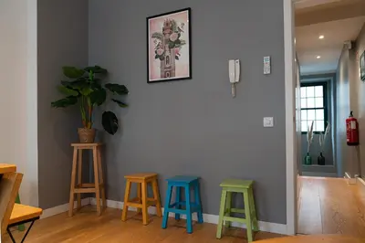 a living room with three stools against a wall at Clerigos Townhouse Porto by PCH in Porto