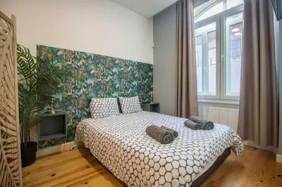 a bedroom with a large bed with a floral wallpaper at Guest H4U - Porto Fontainhas in Porto