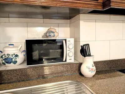 a microwave on a kitchen counter with utensils at Beautiful Infante Apartment in Porto