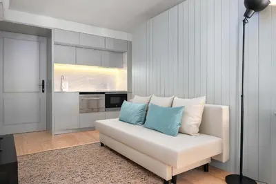 a living room with a white couch with blue pillows at Liiiving in Porto - Santa Catarina Boutique in Porto