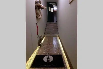 a hallway with stairs with a clock on the wall at Cedofeita Village Porto in Porto