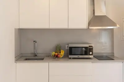 a kitchen with a microwave and a bowl of fruit at Decor Studios - Clérigos by Host Wise in Porto