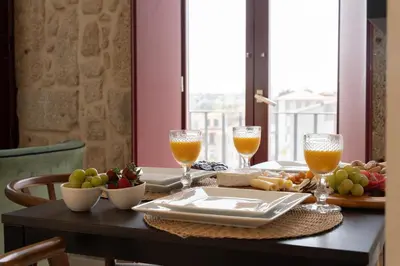 a table with food and two glasses of orange juice at Decor Studios - Clérigos by Host Wise in Porto
