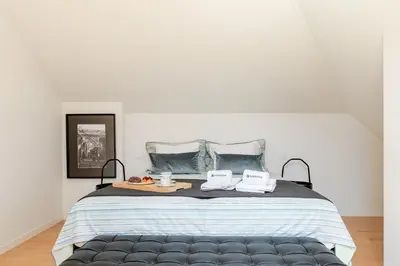 a bedroom with a large bed with two pillows at Decor Studios - Clérigos by Host Wise in Porto