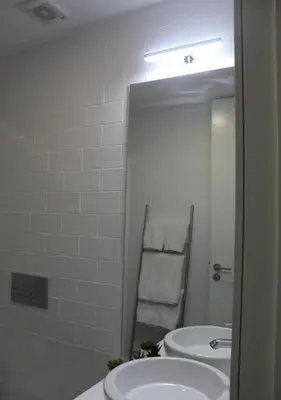 a white bathroom with two sinks and a mirror at Oporto Coliseum Studio in Porto