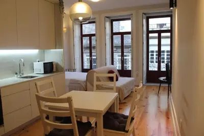 a kitchen and living room with a table and a couch at Oporto Coliseum Studio in Porto