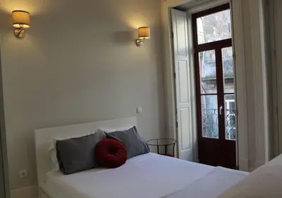 a bedroom with a bed with a red pillow on it at Oporto Coliseum Studio in Porto