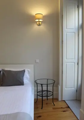 a bedroom with a bed and a table next to a door at Oporto Coliseum Studio in Porto