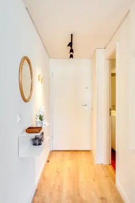 a hallway with a white door and a mirror at DA'HOME - Boavista Green Studio in Porto