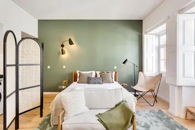 a bedroom with a bed and a chair at DA'HOME - Boavista Green Studio in Porto