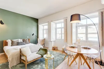 a bedroom with a bed and a table and chairs at DA'HOME - Boavista Green Studio in Porto