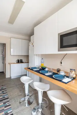 a kitchen with white cabinets and bar stools at Porto Family Home by MP - Renovated in Porto