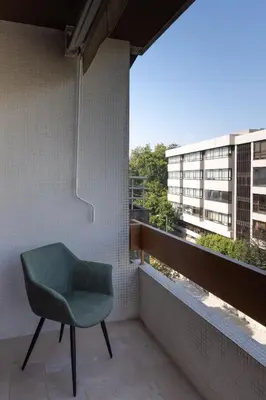 a green chair sitting on a balcony with a window at Porto Family Home by MP - Renovated in Porto
