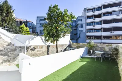 a garden with a table and chairs and a building at Fontinha Square Apartments by Porto City Hosts in Porto