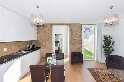 a kitchen and living room with a table and chairs at Fontinha Square Apartments by Porto City Hosts in Porto