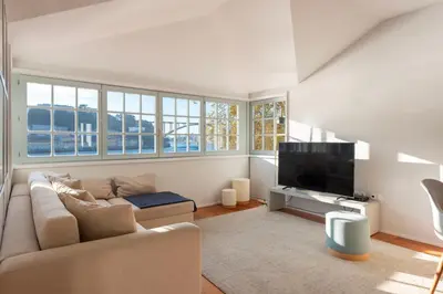 a living room with a couch and a flat screen tv at Duplex Douro River in Porto