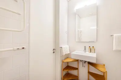 a white bathroom with a sink and a mirror at Bombarda Homes in Porto