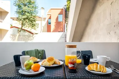 a table with plates of food and oranges and juice at Bombarda Homes in Porto