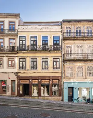 a building on a street with dresses in the windows at 118 Oporto Apartments in Porto
