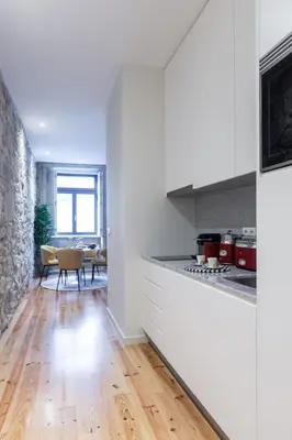 a kitchen with white cabinets and a hard wood floor at Swimming Pool Luxury House 2 in Porto